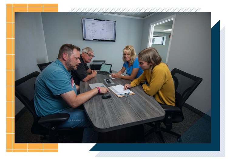 4 employees by a conference table